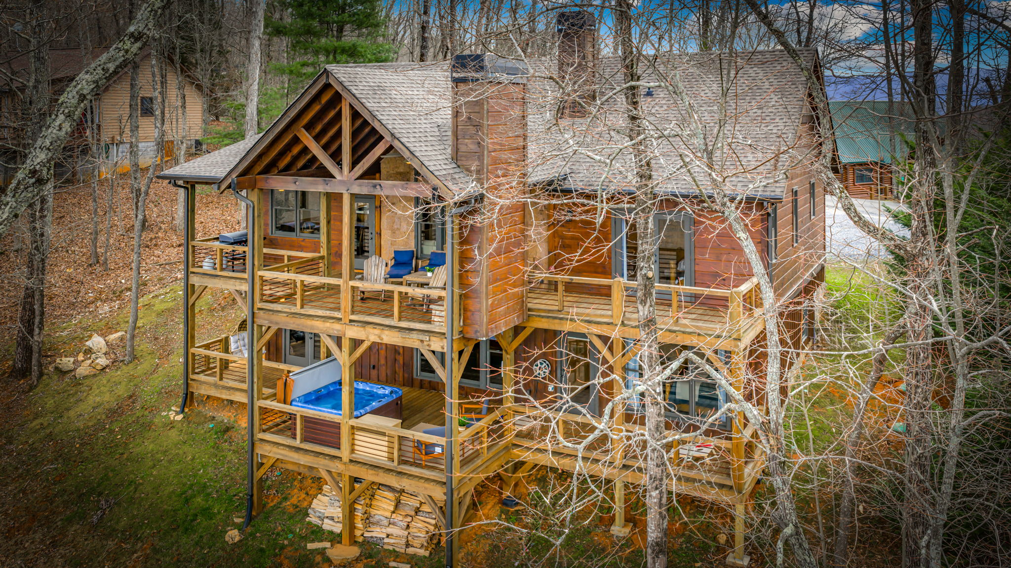 Daytime drone view showing deck structure and wooded setting