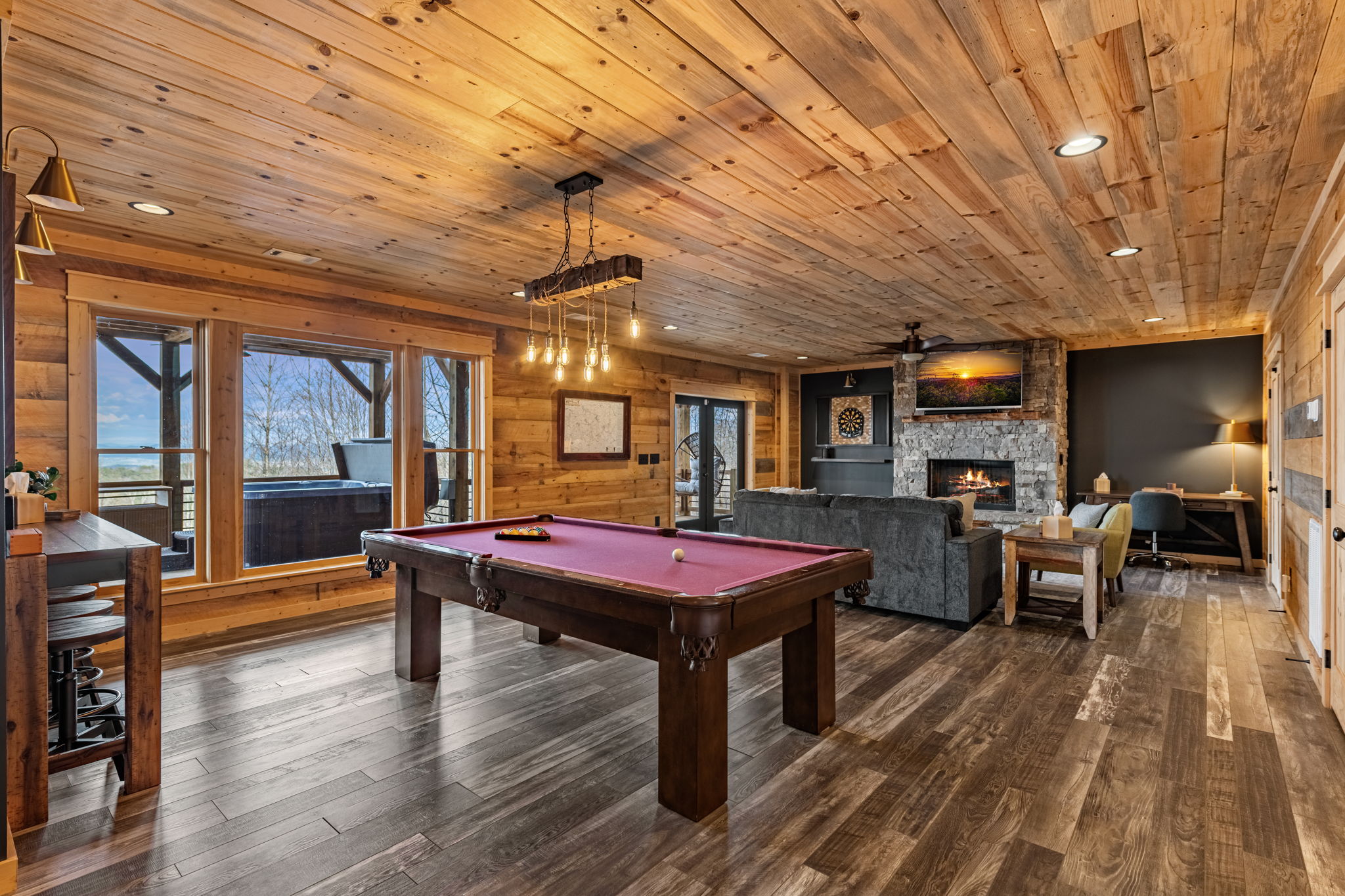 Game room with pool table stone fireplace and wet bar at Blue Ridge GA luxury cabin rental
